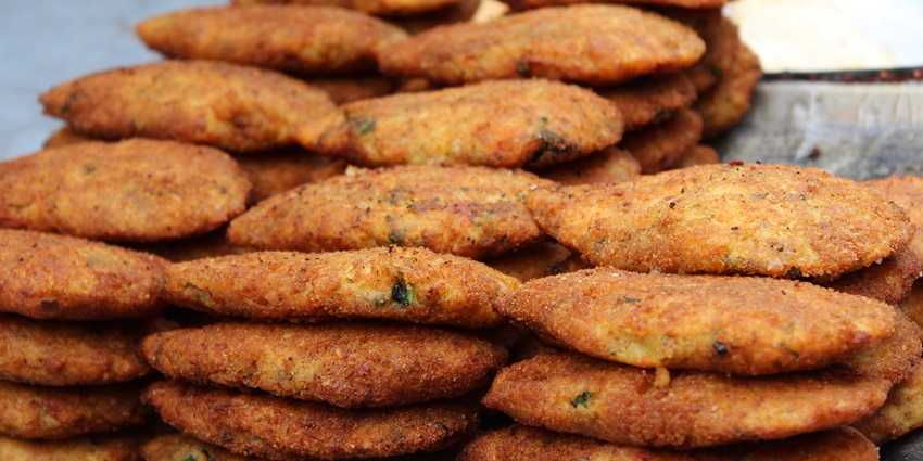 A tempting view of fried potato with different vegetables in it served in a stack.