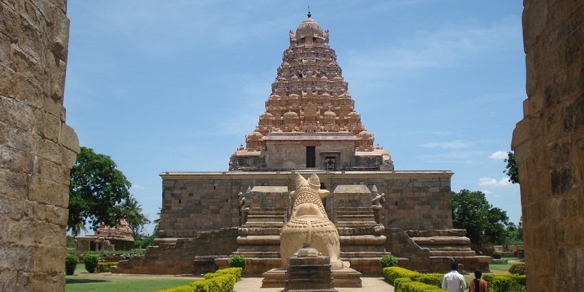 Picture of a place of worship with lush greenery and a scenic backdrop of clear sky.