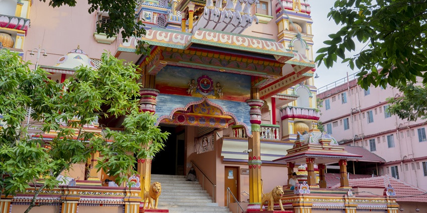 A frontal view of the main entrance of Amritapuri Ashram with colourful wall art all around