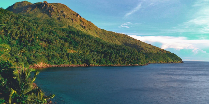 Scenic view of a tranquil island with clear blue waters and lush greenery.