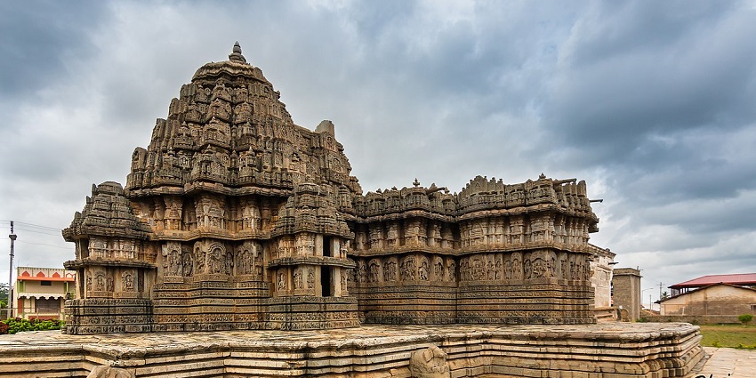 A picture of a holy shrine with intrinsic carvings & cloudy skies in the background.