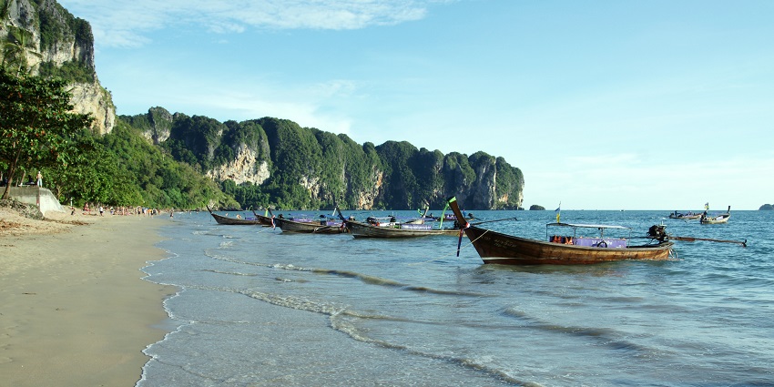 A breathtaking view of boats standing on the seashores of Ao Nang Beach in Thailand.