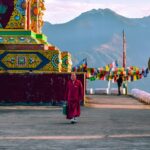 A stunning view of a red and yellow temple with colourful decorations during the day.