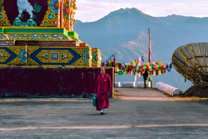 A stunning view of a red and yellow temple with colourful decorations during the day.