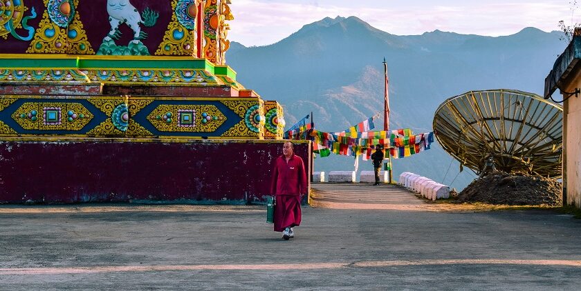 A stunning view of a red and yellow temple with colourful decorations during the day.