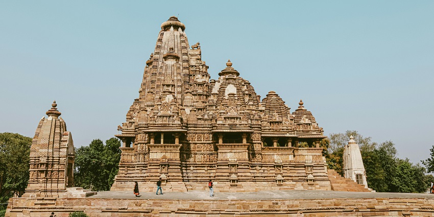 A glimpse of Ashapuri Devi Temple adorned with rustic hues and surrounded by greenery.
