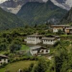 A mesmerising view of concrete white houses with brown roofs encircled by lush meadows.