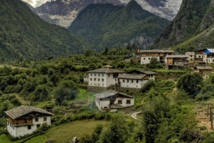 A mesmerising view of concrete white houses with brown roofs encircled by lush meadows.