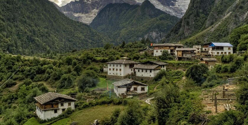 A mesmerising view of concrete white houses with brown roofs encircled by lush meadows.