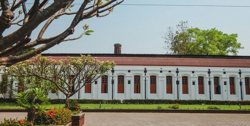 A stunning view of a white and red concrete building with windows during the daytime.