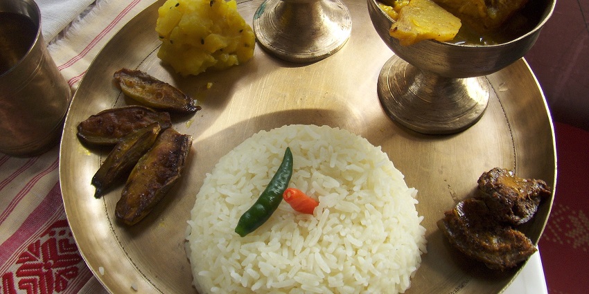A picture of a delectable dish of Assam which is served in traditional brass utensils.