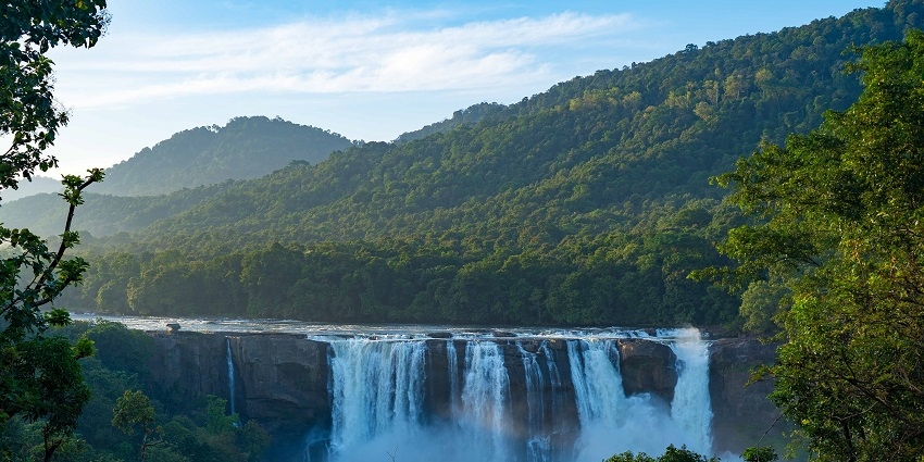 A view of Athirappilly Waterfalls after rain showers and surrounded by lush greenery.