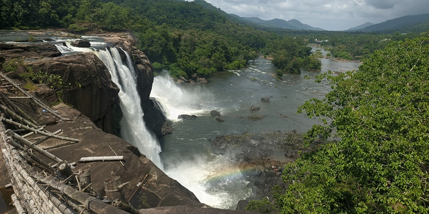 A Wide-angle beautiful shot of Athirappilly Waterfalls taken from a distance in Kerala