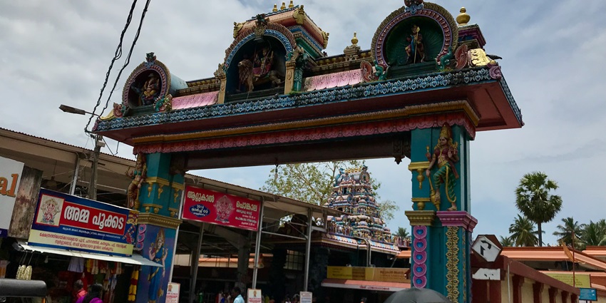 A picture of the entry gate of a temple in Kerala with sculptures of deities over it