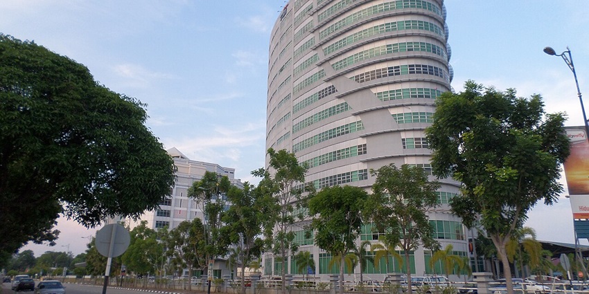 A serene view of Ayer Keroh featuring majestic buildings and lush green vegetation.