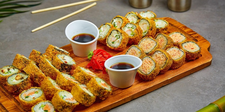 A picture of a sushi platter served at a Chinese restaurant with a sauce on the side