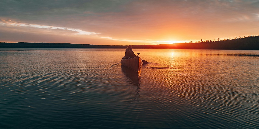  Person paddling a kayak on a calm body of water, kayaking adventure in Vietnam.