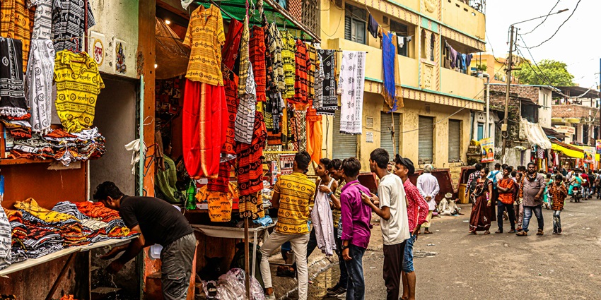 A picture of people buying clothes and garments from a roadside stall