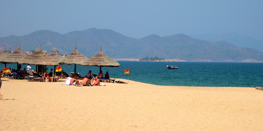 People leisurely sitting at Bai Tru Beach, one of the best beaches in Nha Trang.