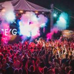 A fascinating view of a group of people dancing and enjoying to techno music under lights.