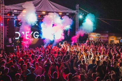 A fascinating view of a group of people dancing and enjoying to techno music under lights.