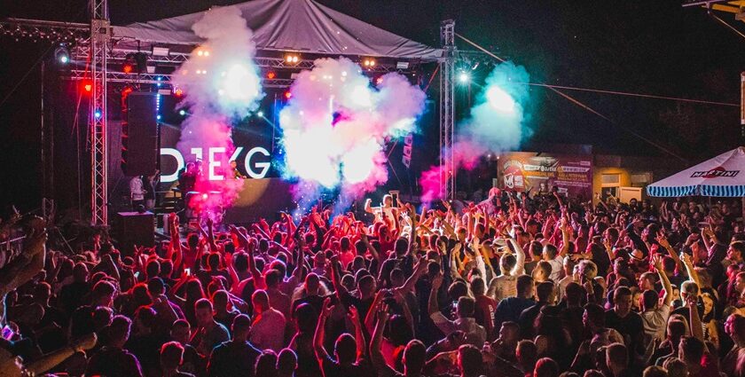 A fascinating view of a group of people dancing and enjoying to techno music under lights.