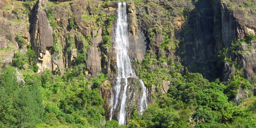 Stunning view of Bambarakanda Waterfall cascading down lush green mountains in Sri Lanka.