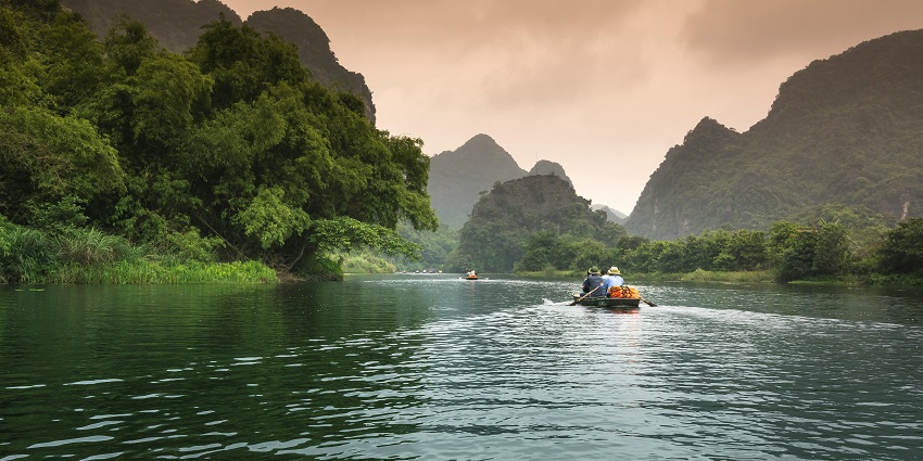 A picture showing a banana boat sailing through a river in Bali