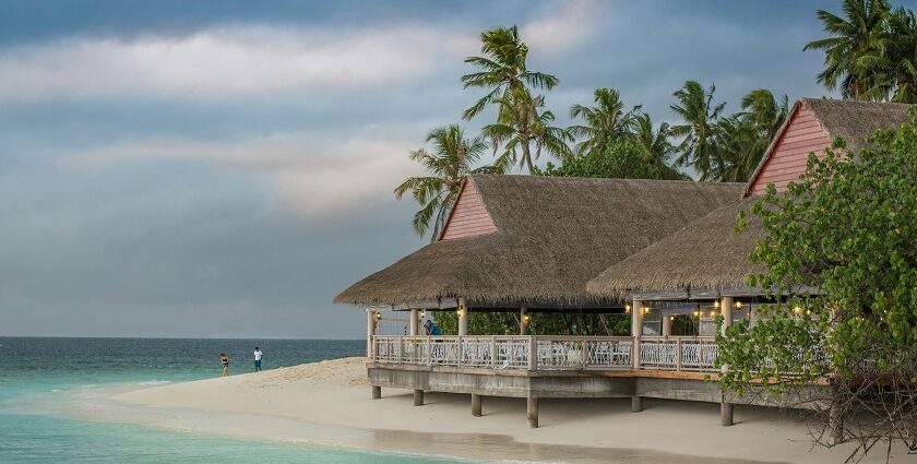 A mesmerising view of a brown hut near a body of turquoise water during the day.