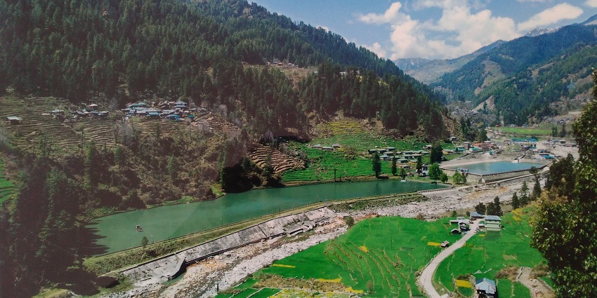 A mesmerising view of the Barot Valley surrounded by lush greenery during the daytime.