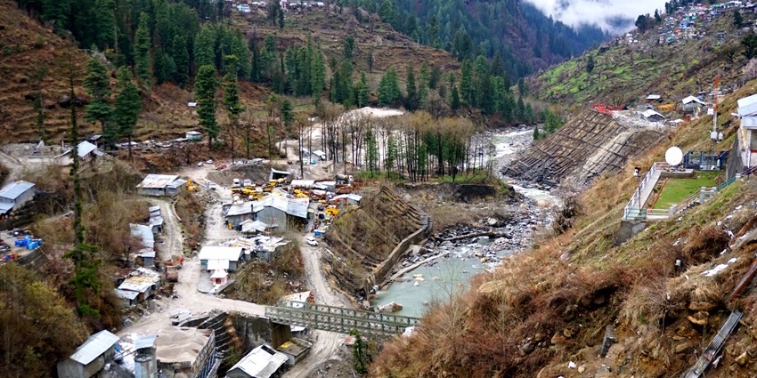 An aerial view of Barshaini featuring towering peaks, rolling hills, and quaint rivers.