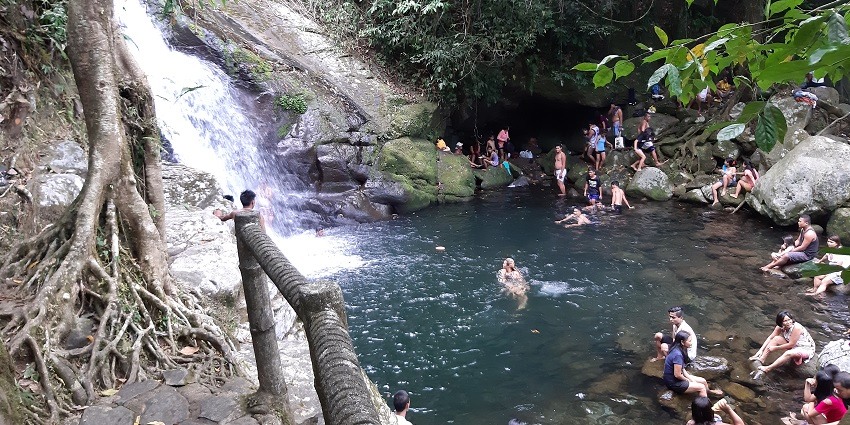 People bathing in the natural waterfall pool