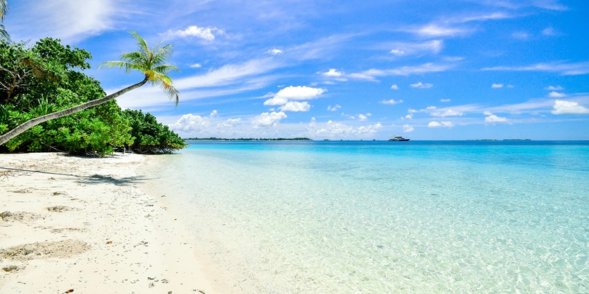 Beautiful beach with golden sand, clear blue waters, and a serene, sunny atmosphere.