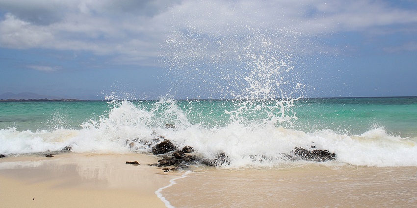 Gentle waves rolling onto the sandy beach under a clear blue sky - beaches in Koh Samui