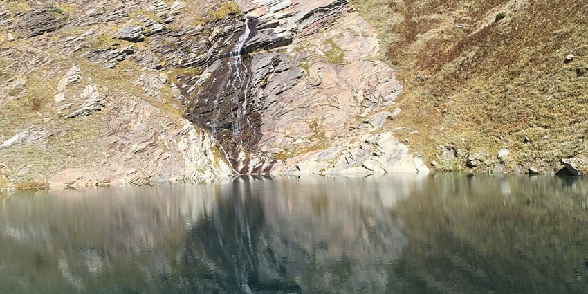 Panoramic view of the mountains reflecting in the Beas Kund, a perfect place to escape and relax