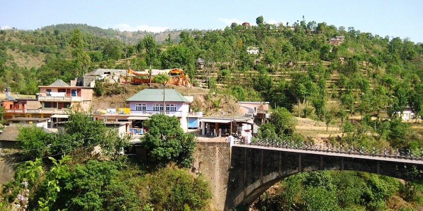 A mesmerising view of Mandi in Himachal Pradesh with lush greenery and clear sky.