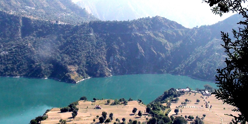 A picture of a scenic landscape in Chamba with a river and mountains in the background