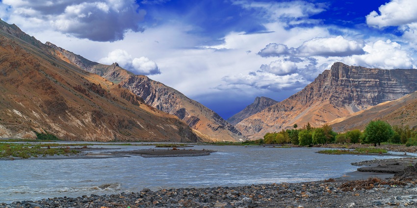 A breathtaking view of the Spiti Valley with snow-covered mountains in the background.