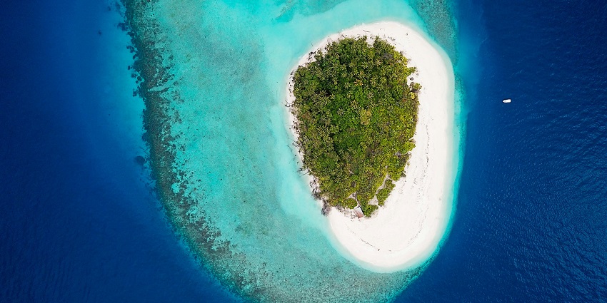 A mesmerising view of an island from above with sparkling waters and lush greenery.