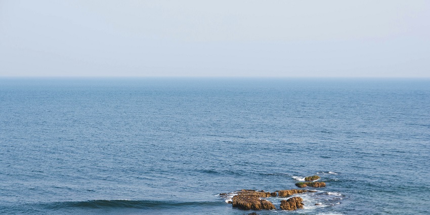 A mesmerising view of a turquoise water body with small rocks in it during the day.