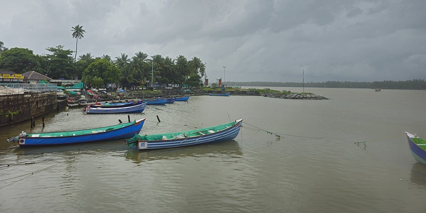A picture of a beach in Kozhikode with numerous boats parked around