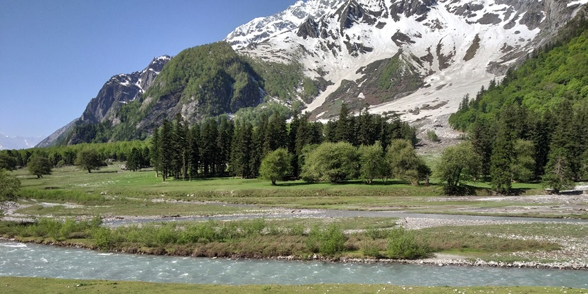 Image of Bhaba Valley surrounded by lush green and snow-covered mountains during day time view