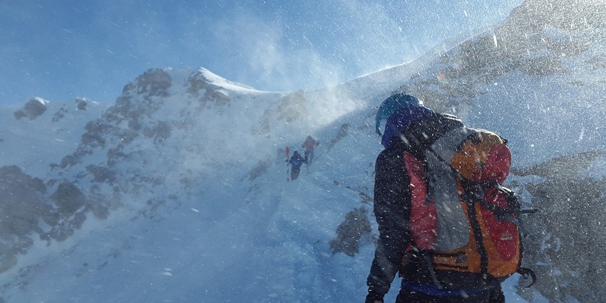 A picture of a person trekking in the Himalayan range with a bedsheet of snow surrounding him