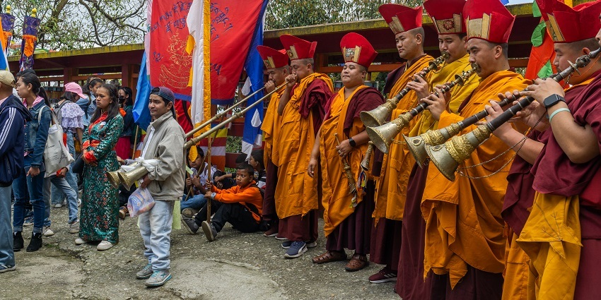 Monks playing trumpets at Bhutia Monastery, a place to visit in Darjeeling in December.