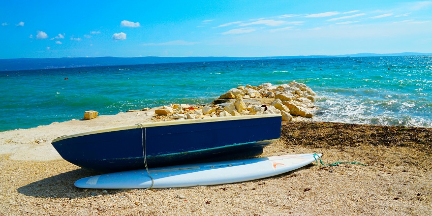 Blue wooden dinghy boat resting on sandy shore - Hidden beaches in Sri Lanka.