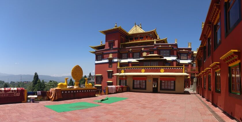 A day light photograph of Ngedon Chokhor Ling Monastery with carpets spread around.