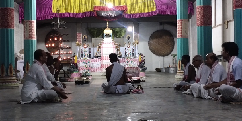 A picture of a prayer hall in Nagaon, Assam, with devotees meditating and worshipping