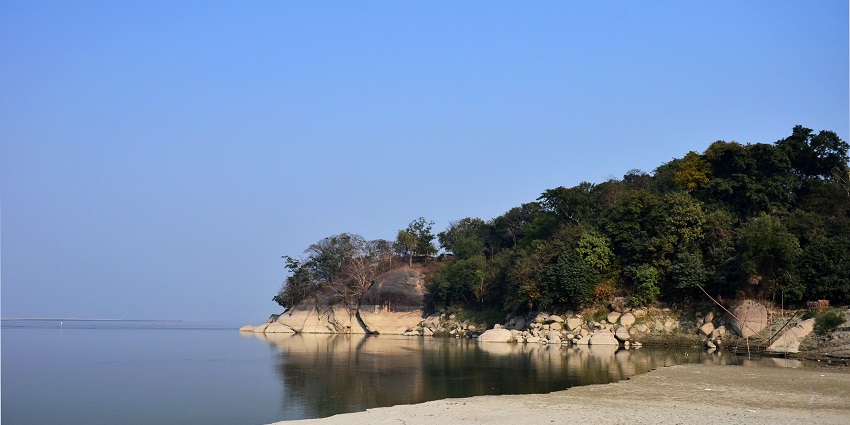 Scenic view of the Brahmaputra River, showcasing lush greenery along the banks and waters.