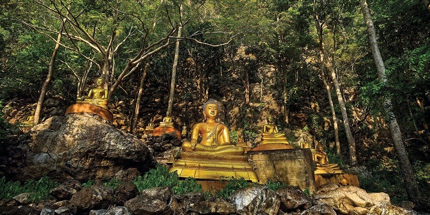 Wat Thum Nam in Ratchaburi, a temple surrounded by lush greenery and serene waters.