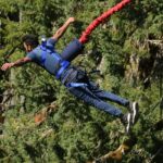 A man tied to a harness and indulging in freefall which is a thrilling activity to try.